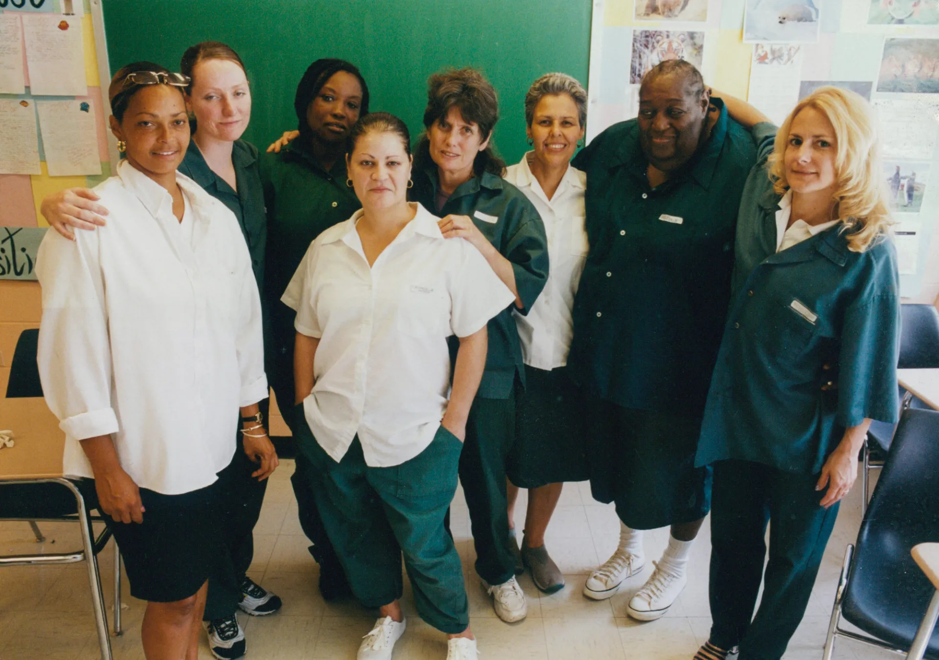 A group of women posing for a photo in white and deep green clothing