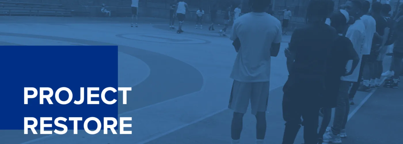 A picture of young people playing basketball outside with a blue overlay and text that says "Project Restore"