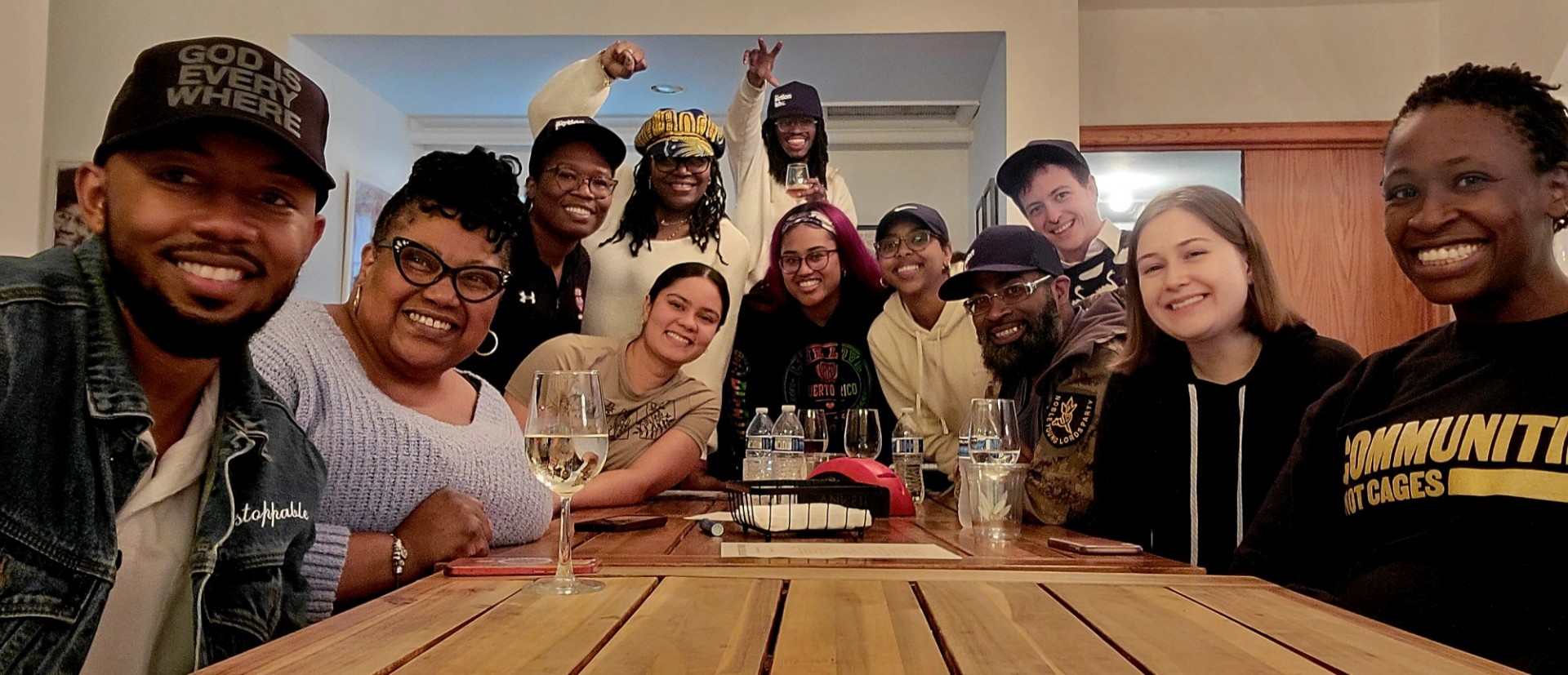 A group of people sitting around a table smiling