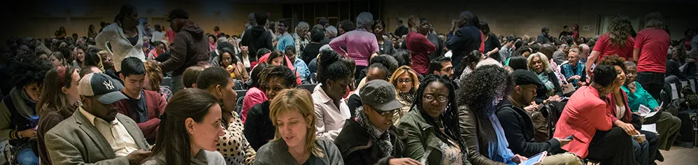 A room full of justice conference participants interact.