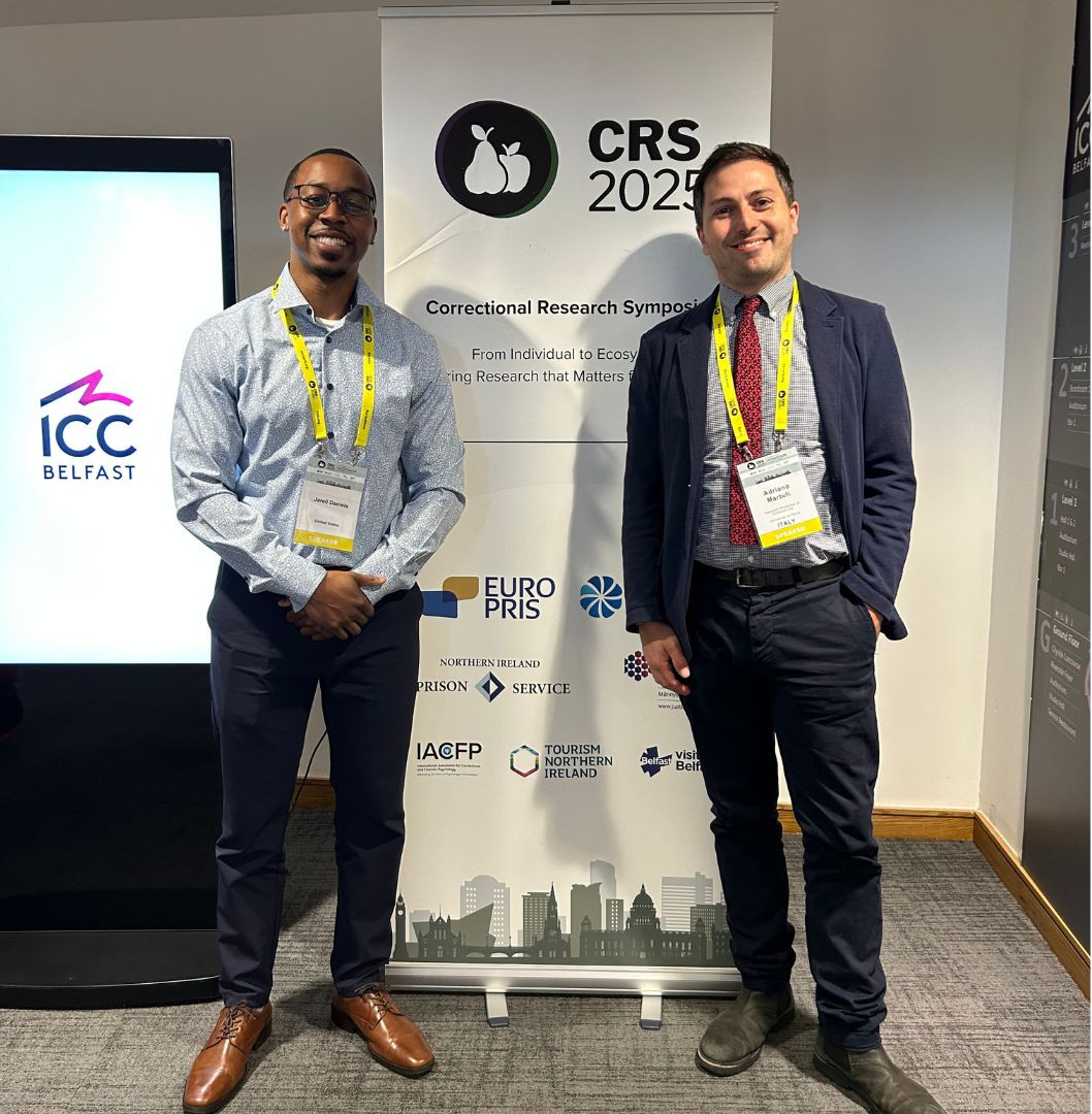 Two men standing in front of a conference banner