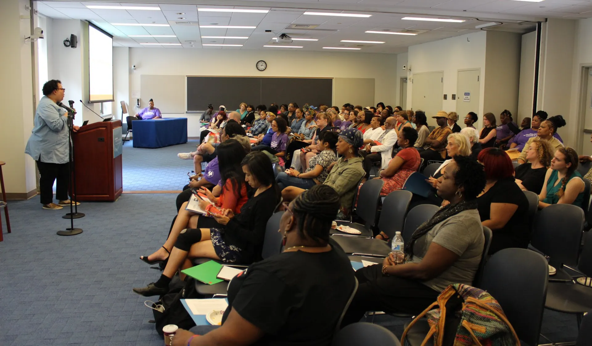 Various community leaders seated in room at Columbia School of Social Work listening to speaker