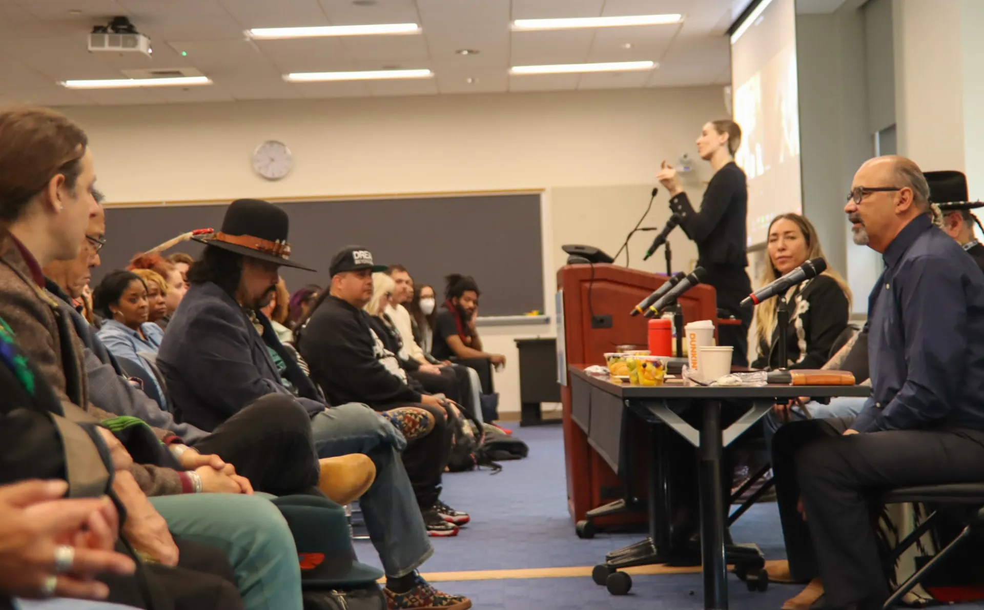 Photo from the side of a panel of speakers that includes the crowd