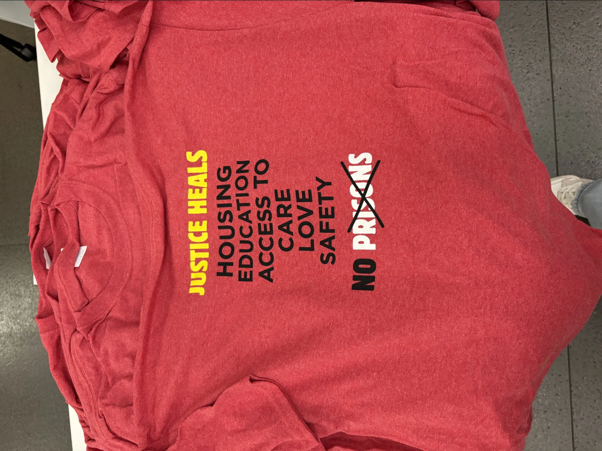 Shirt that says Justice Heals: Housing, Education, Acccess to Care, Love, Safety and No Prisons