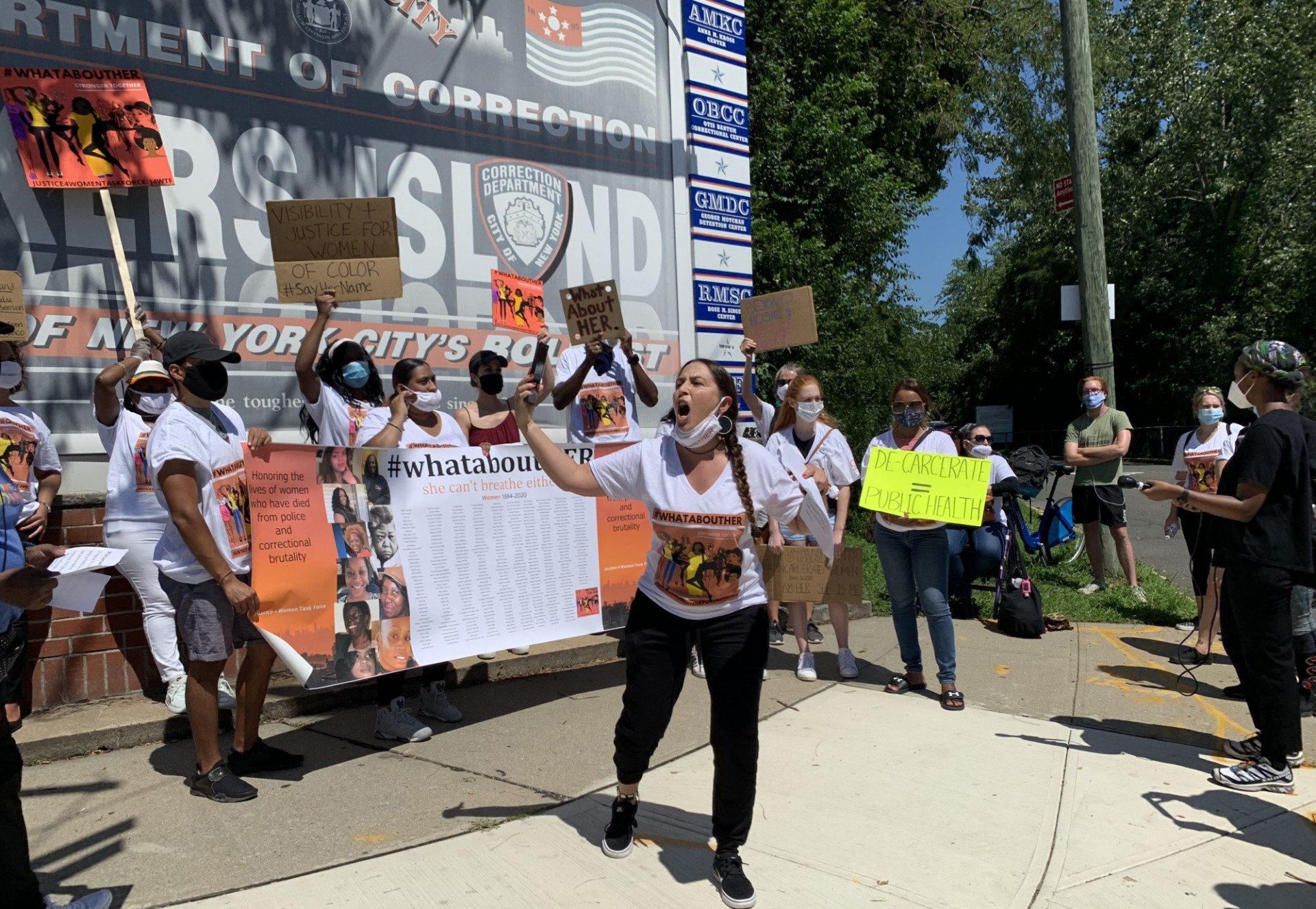 Group of women rallying outside Rikers Island sign