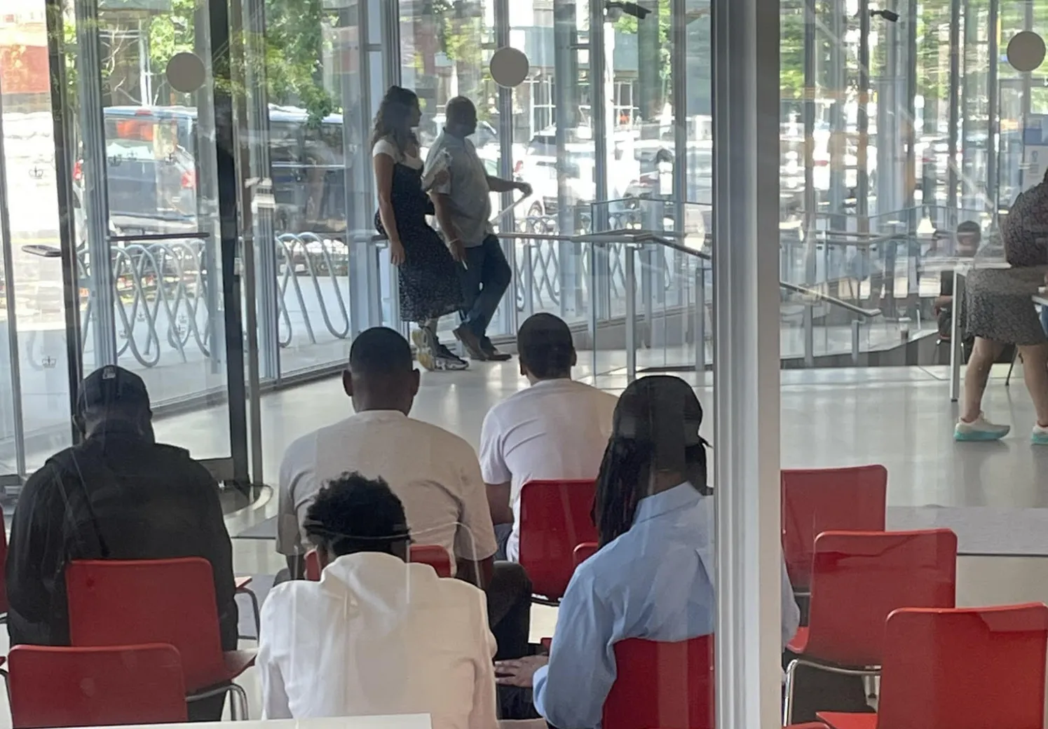 Photo of the backs of people sitting in chairs listening to a speaker 