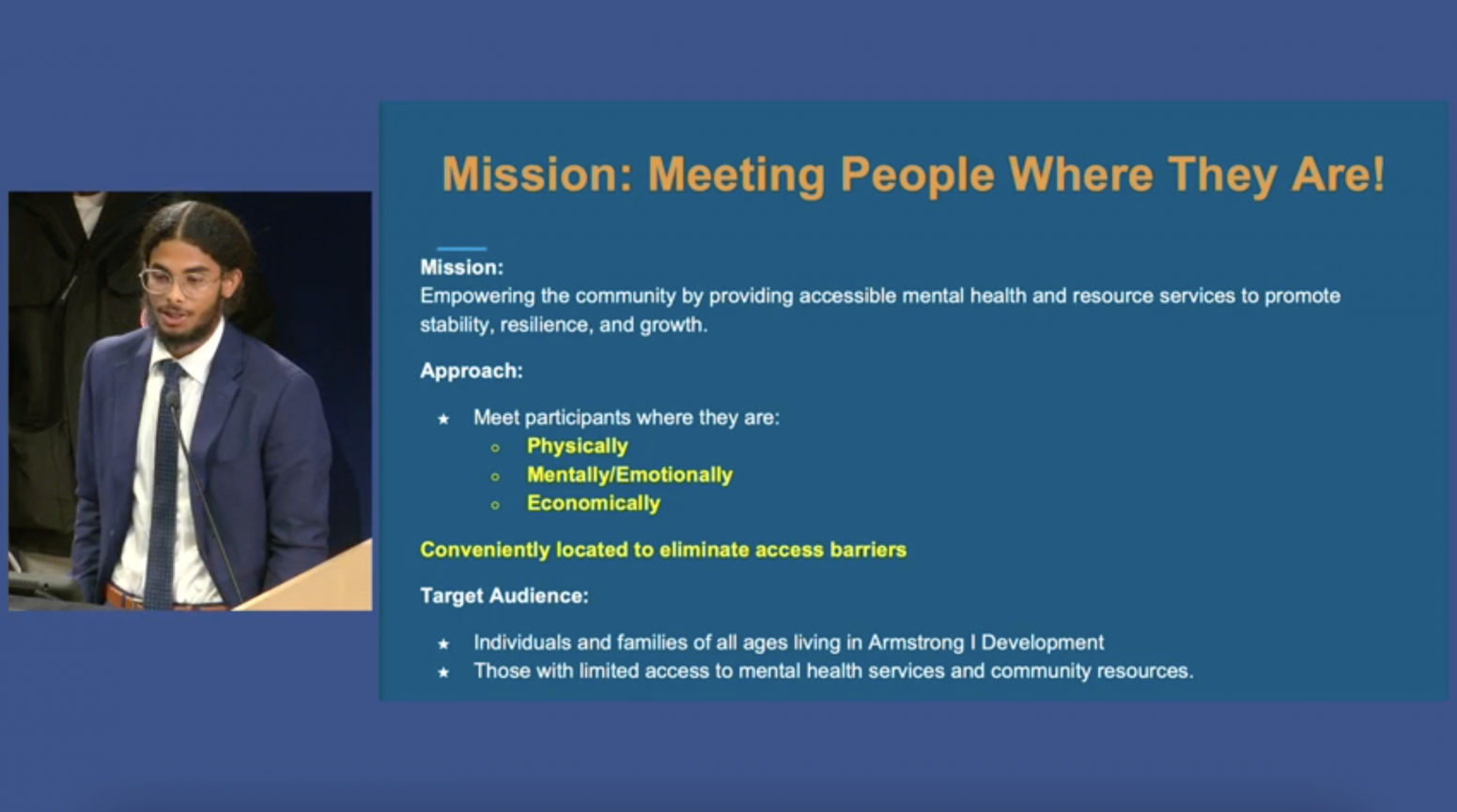 A young Black man in a suit and glasses next to a screen that says "Mission: Meeting People Where They Are!" with additional information on the policy proposal