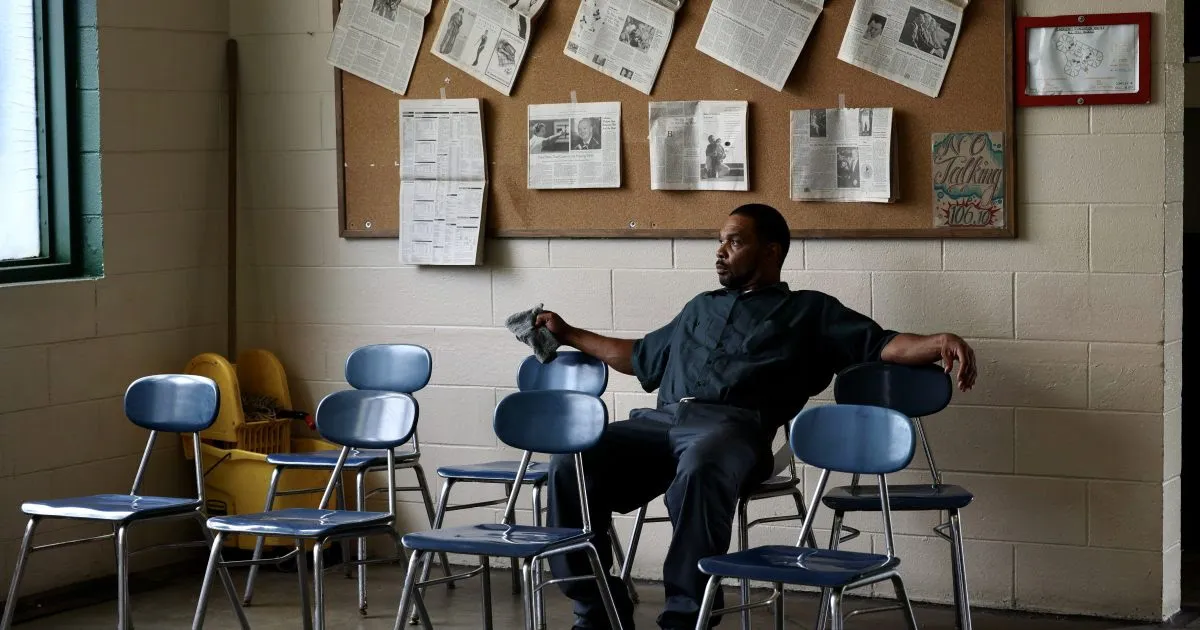 Photo of a man sitting on a chair in an in-prison classroom