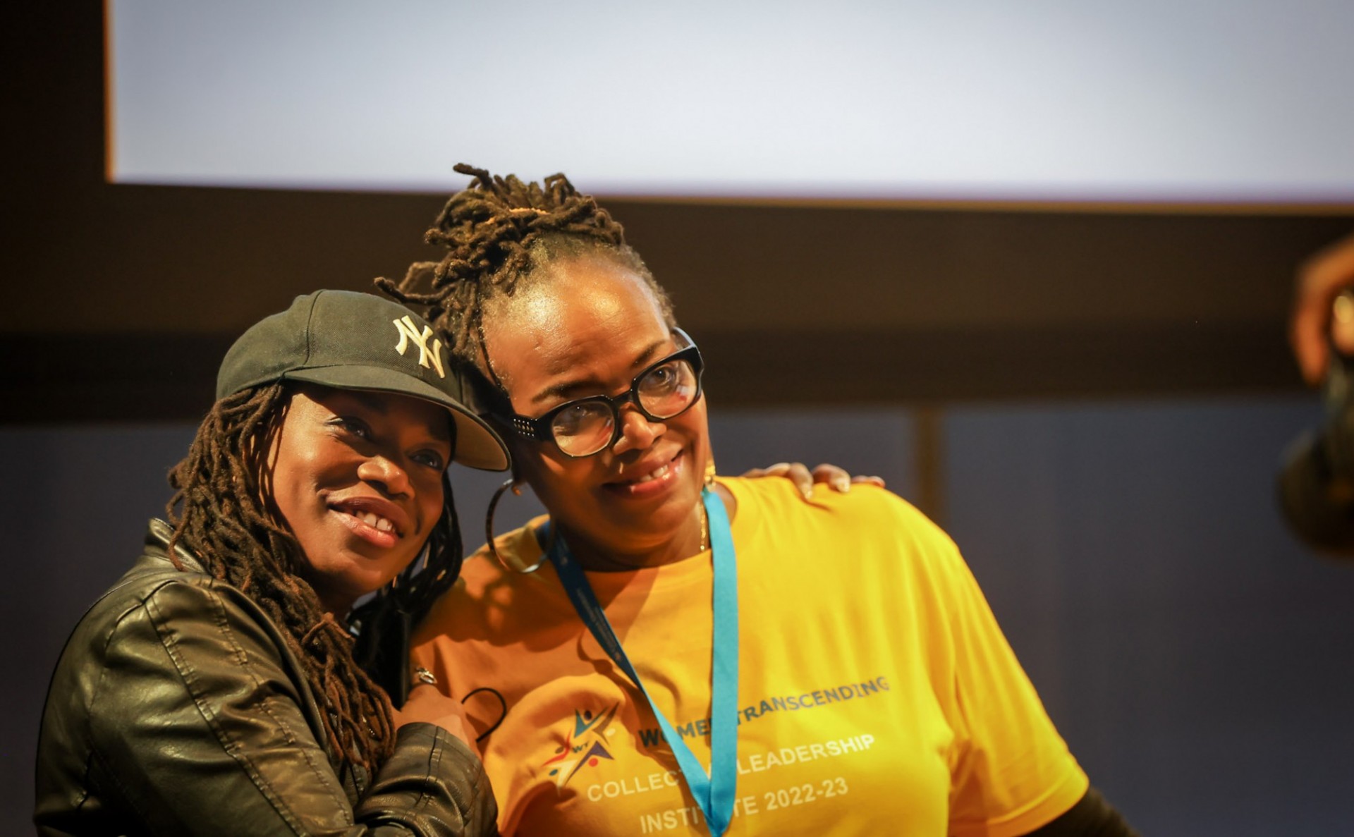 a picture of two Black women posing and smiling 