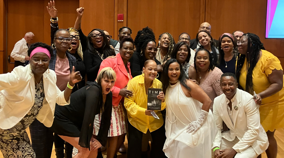 Group of mostly women smiling with fists in the air