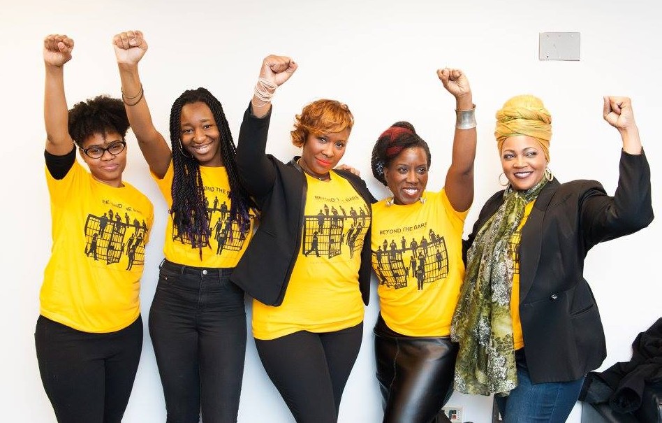 Women from Beyond the Bars appear with their fists raised in the air.