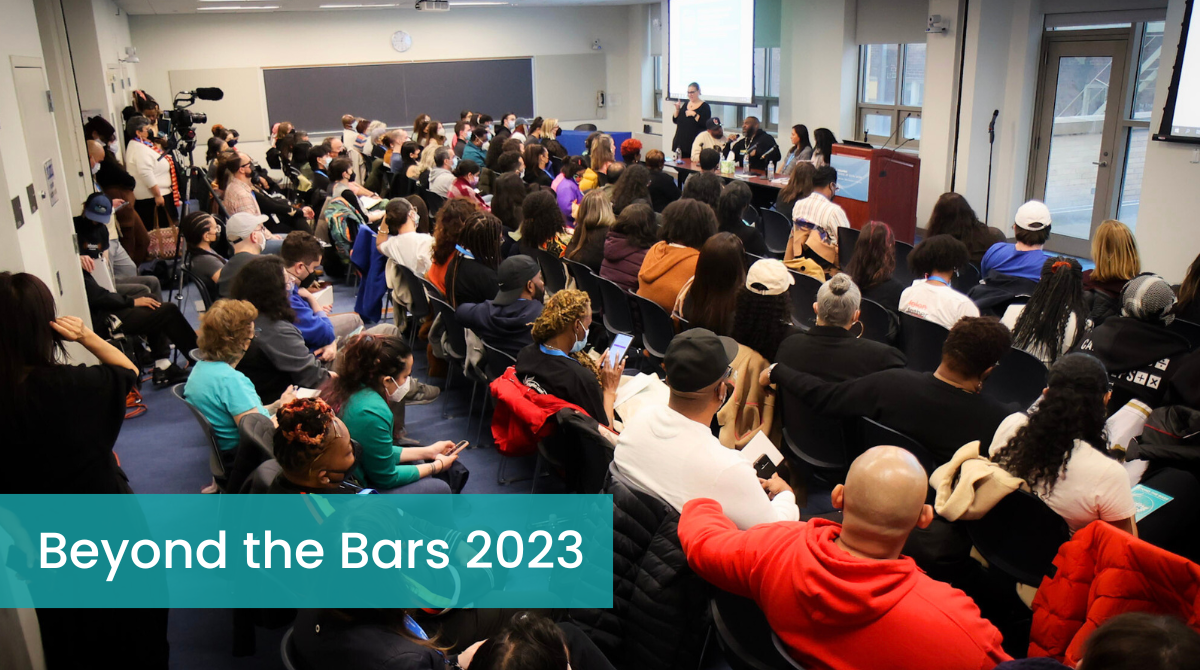 Large group of people in a classroom listening to a panel