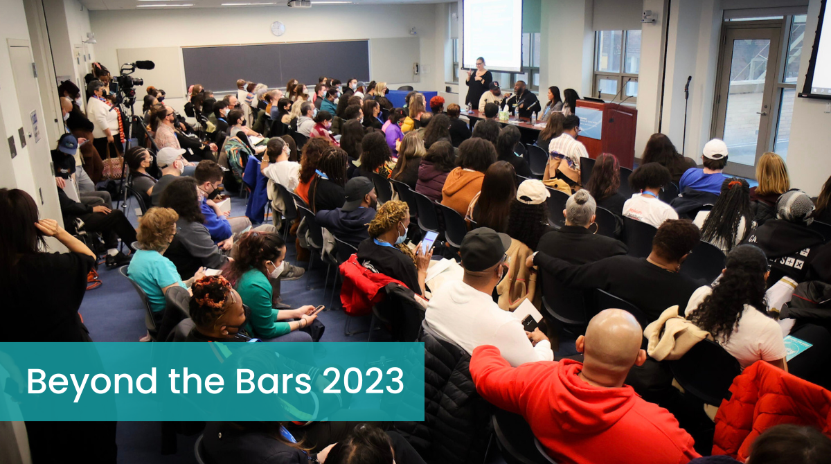 Large group of people in a classroom listening to a panel 