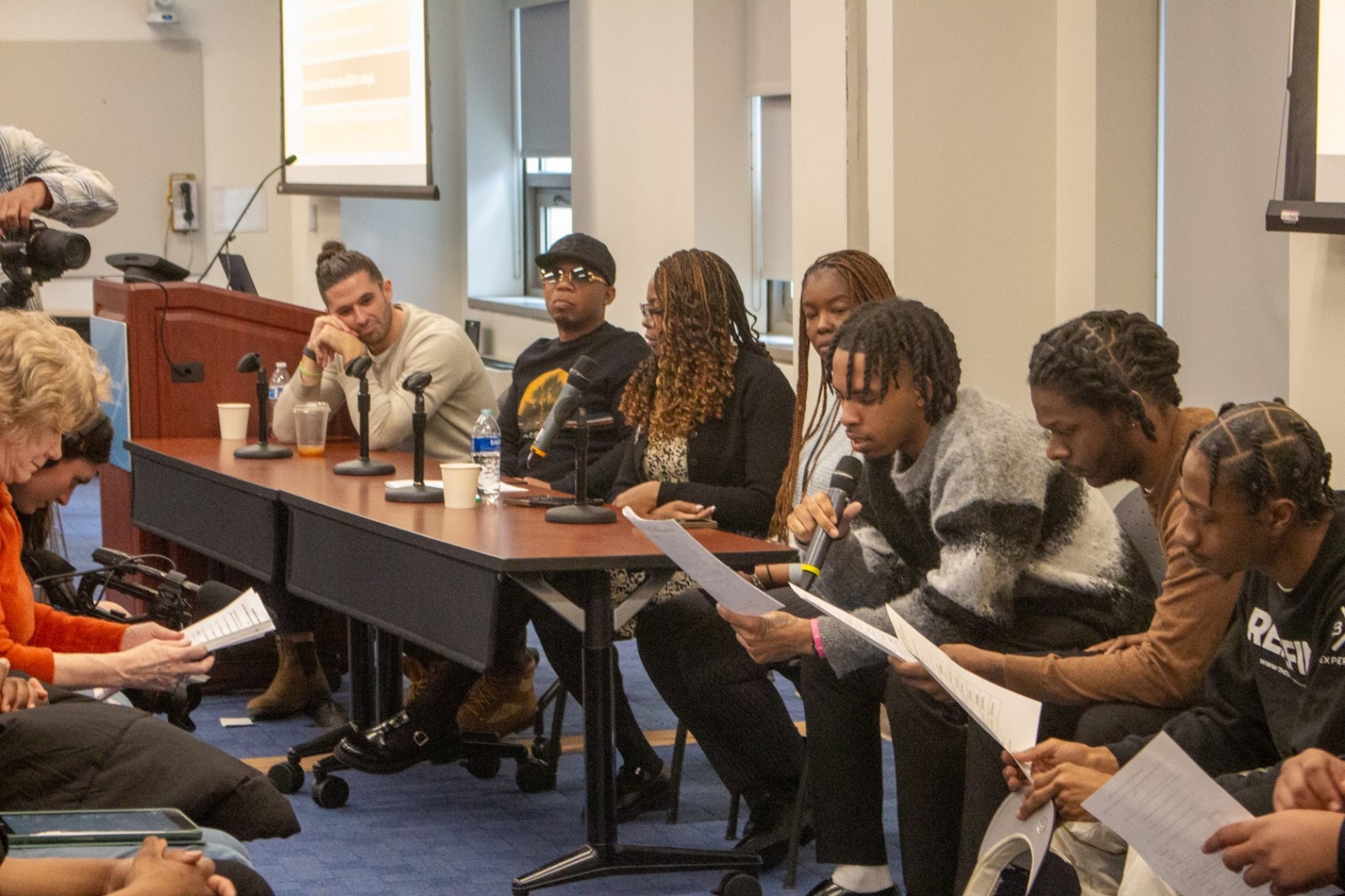 A group of youth sitting on a panel speaking