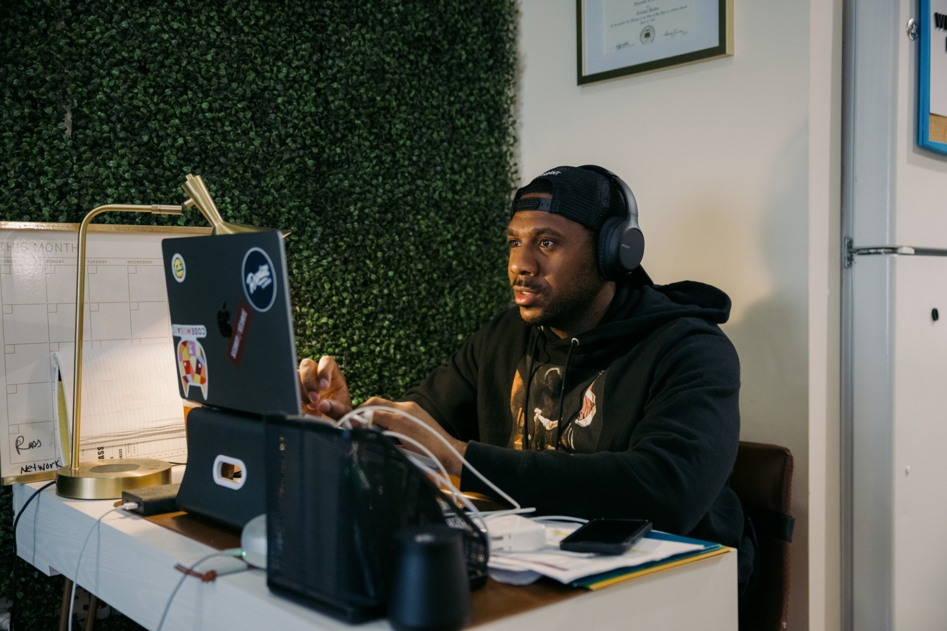 A man sitting at a laptop with headphones on