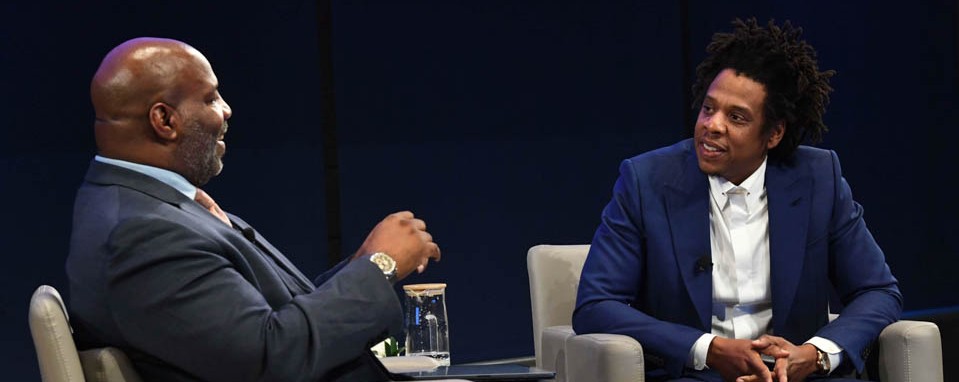 Jay-Z and Jelani Cobb appear seated onstage