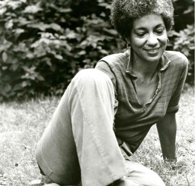 June Jordan seated in the grass.
