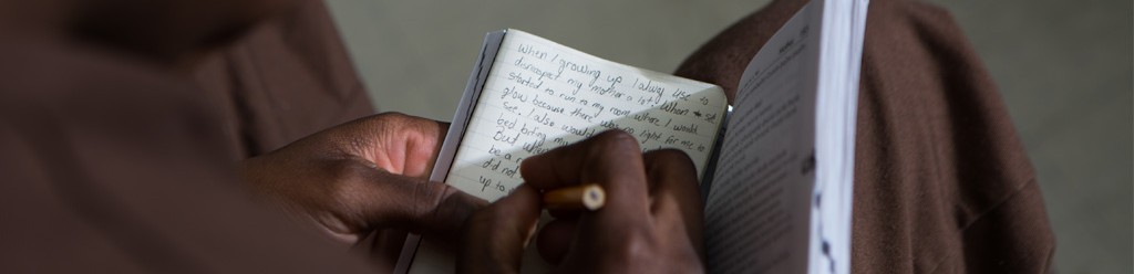 Incarcerated student writing in a journal