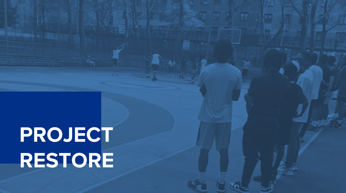 A picture of young people playing basketball outside with a blue overlay and text that says "Project Restore"