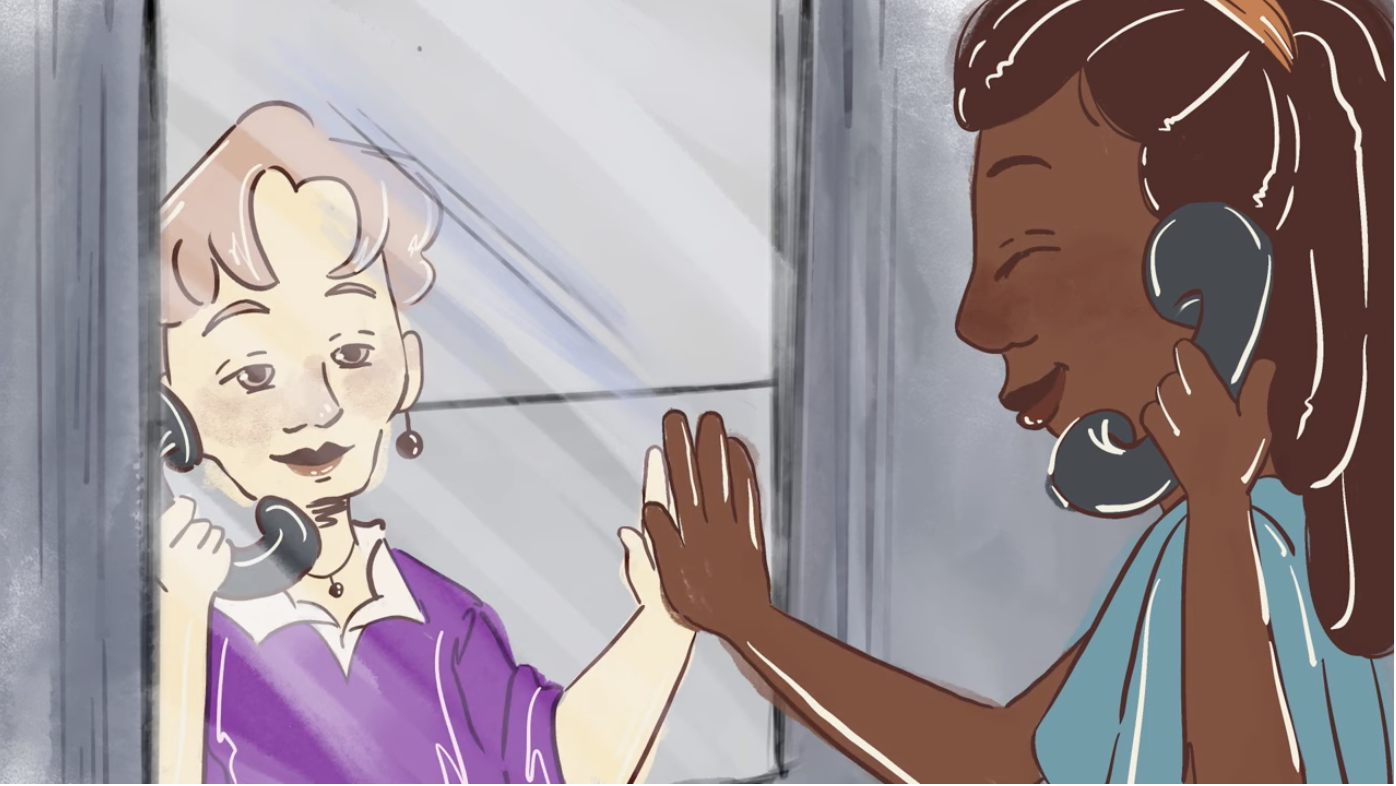 Screenshot of animated video of two people talking over the phone at a prison and both are putting their hands up to the glass and smiling
