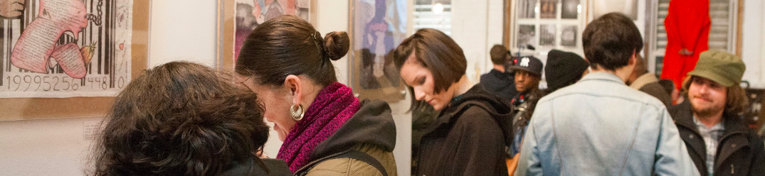 The Confined Arts event participants observe artwork.
